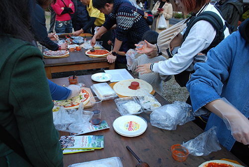 ナイスバーベキューガーデンで手作りピザ体験に興じる参加者たち